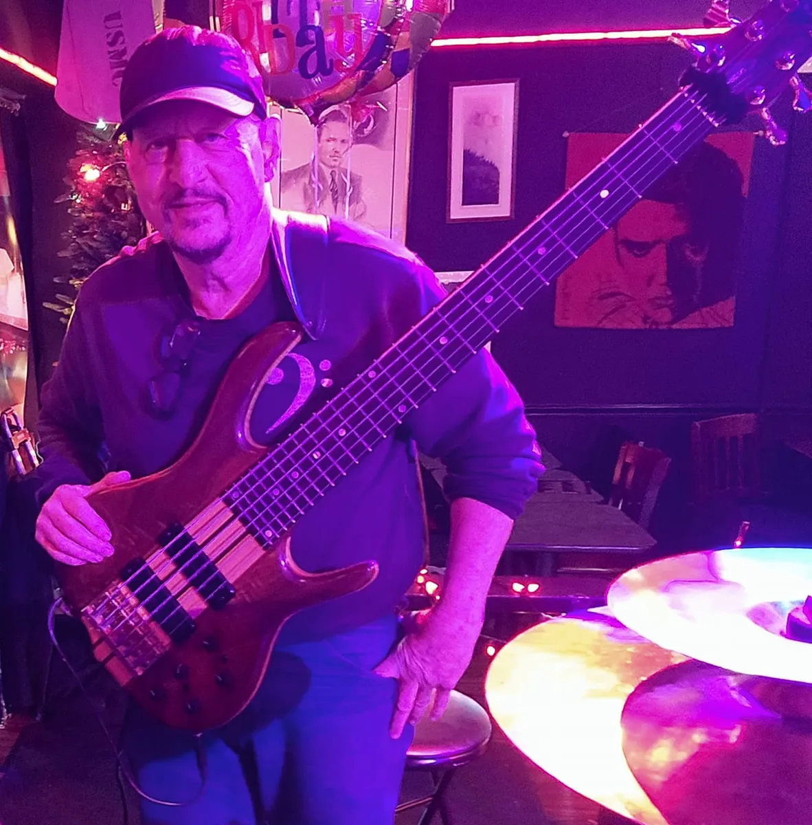 Russ Rodgers playing bass under dramatic purple stage lighting