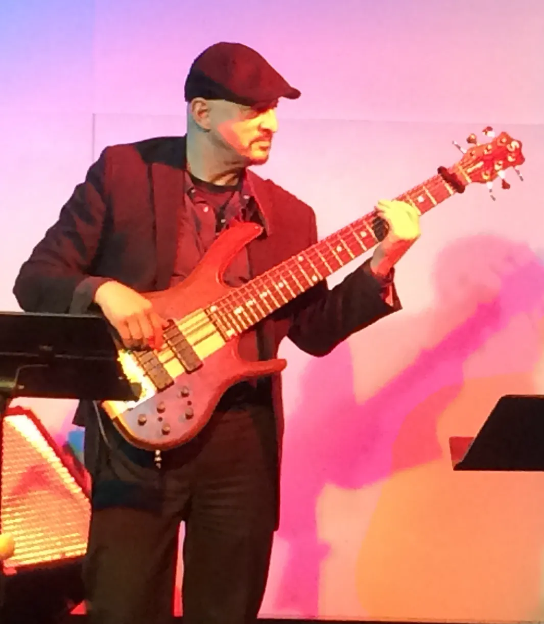 Russ Rodgers on stage playing his Ken Smith bass under red lighting