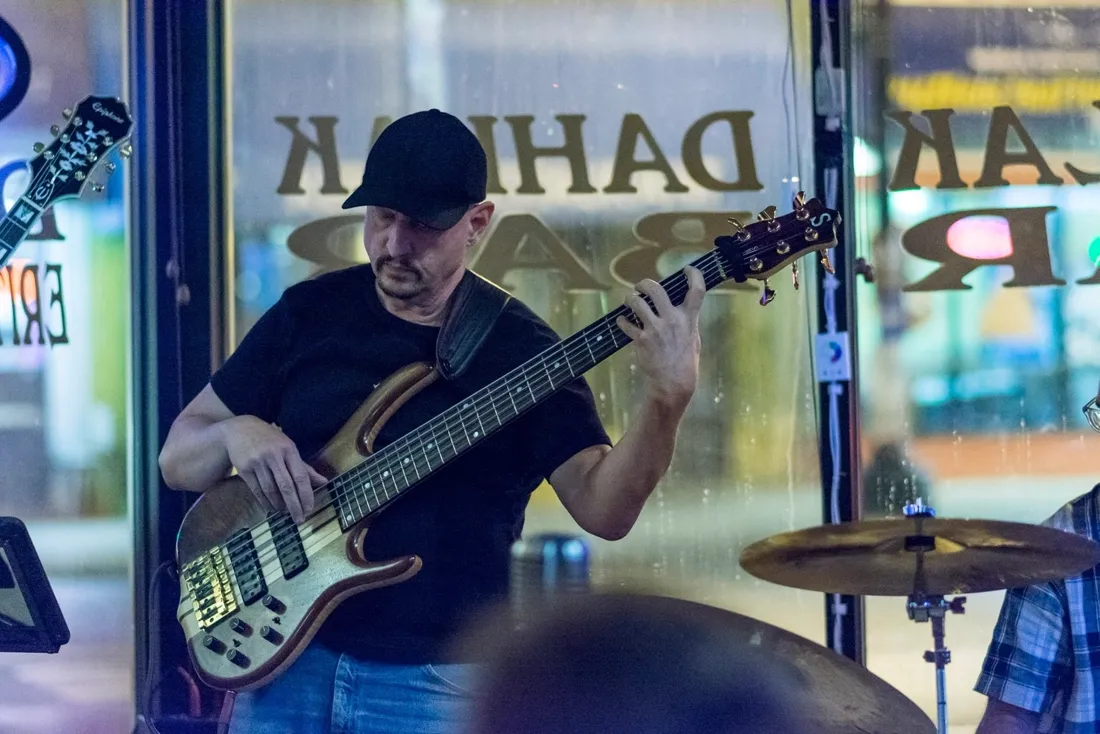 Russ Rodgers playing bass at a street-side bar gig at night