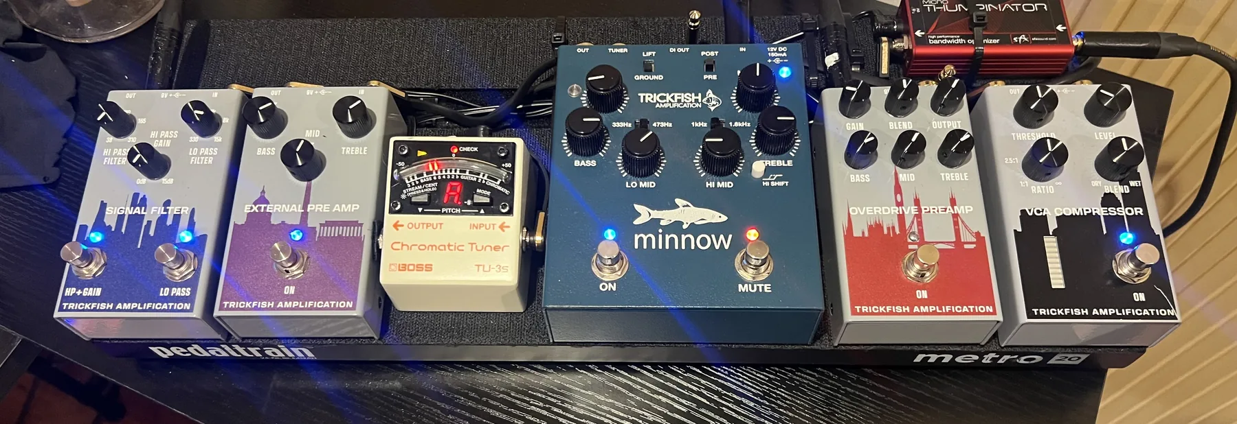 Russ's rock and blues board on a Pedaltrain Metro, left to right: Trickfish Signal Filter, Trickfish External Pre Amp, Boss TU-3S tuner, Trickfish Minnow, Trickfish Overdrive Preamp, and Trickfish VCA Compressor, with the SFX Micro-Thumpinator at the back