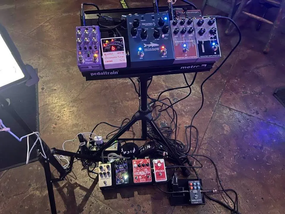 Both pedalboards deployed at a gig — the Metro board on its stand with the Trickfish chain, the effects board on the floor below